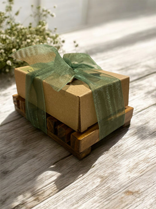 Gift box with a green ribbon on a wooden surface